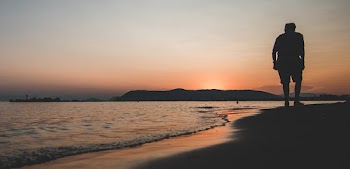 Photo Of Person Walking On Seashore