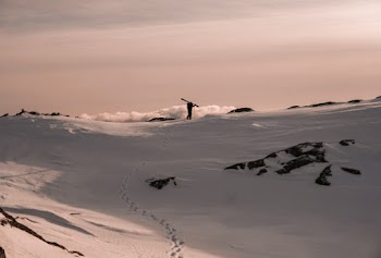 Photo of Person Walking on Snowy Field