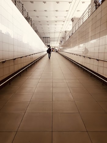 Photo of Person Wearing Backpack Walking in Hallway
