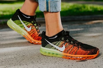 photo of person wearing black-yellow-and-red Nike lace-up shoes