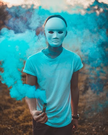 Photo of Person Wearing Mask Surrounded With Smoke