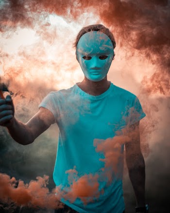 Photo of Person Wearing Mask Surrounded With Smoke