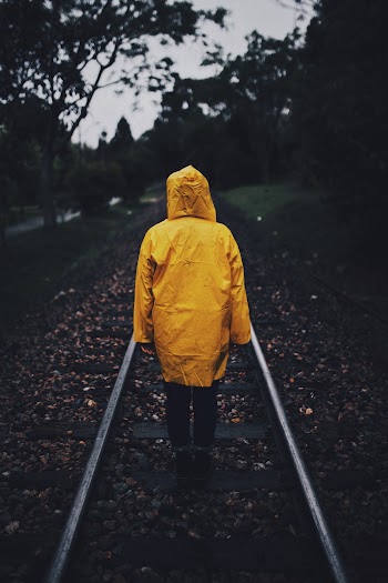 Photo of Person Wearing Raincoat in a Railway