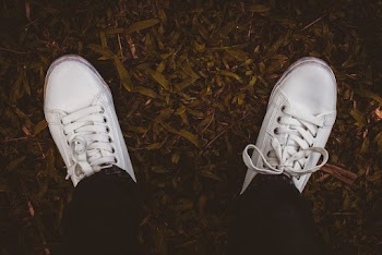 Photo of Person Wearing White Sneakers
