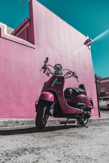 Photo of Pink Motor Scooter Parked Next to Pink Wall