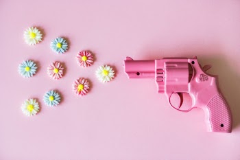 Photo of Pink Revolver Pointed At Flowers