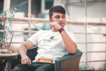 Photo of Posing Man Looking Away Sitting on Armchair