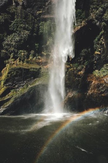 photo of rainbow near waterfall