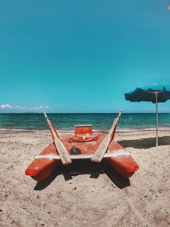 Photo of Red Watercraft on Seashore