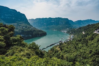 Photo of River Near Mountains Covered With Trees