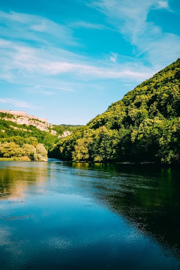Photo of River Near Trees Under Blue Sky
