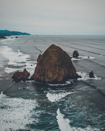 Photo Of Rock Near Ocean During Daytime
