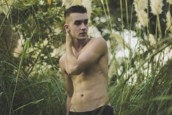Photo of Shirtless Man Posing For Camera