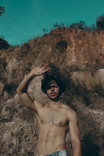 Photo of Shirtless Man Raising His Right Hand