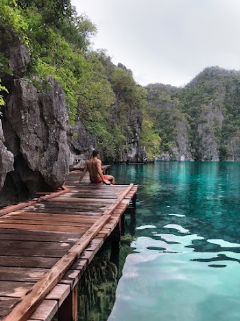 Photo of Shirtless Man Sitting on Wooden Planks