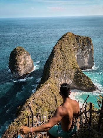 Photo of Shirtless Man Standing Near Wooden Fence