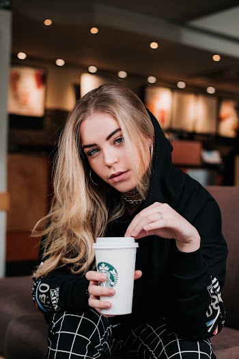 Photo of Sitting Woman Holding a Starbucks To Go Cup