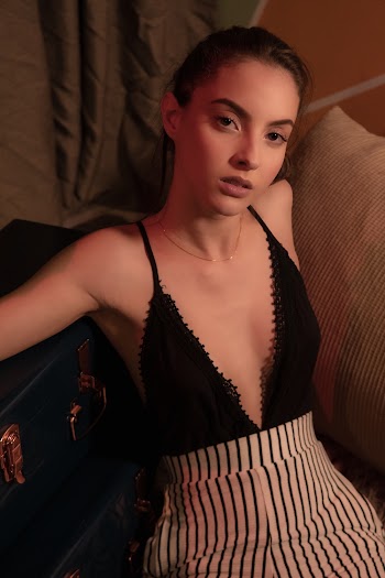 Photo of Sitting Woman in Black Deep V-neck Spaghetti Strap Top Posing