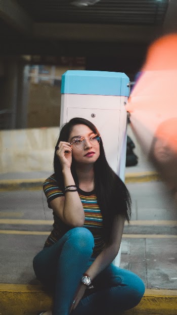 Photo of Sitting Woman Wearing Striped Shirt and Blue Pants