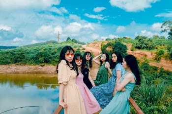 Photo of Six Woman Sitting on Dock Fence