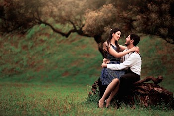 Photo of Smiling Couple Sitting on Tree Trunk