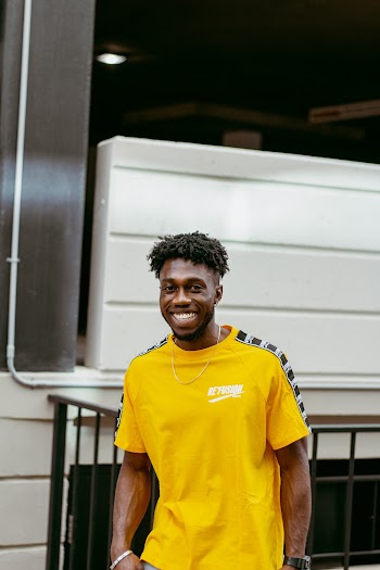 Photo of Smiling Man in Yellow Crew-neck T-shirt Posing