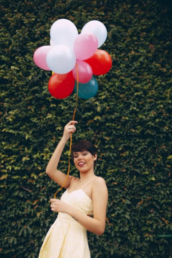 Photo of Smiling Woman Holding Balloons