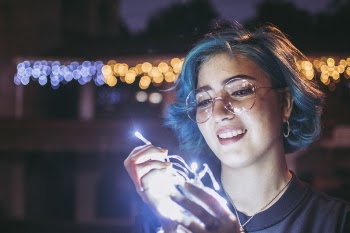Photo of Smiling Woman Holding String Lights