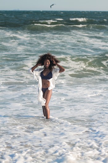 Photo of Smiling Woman in Bikini Posing By The Beach