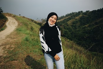 Photo of Smiling Woman in Black Hijab Posing by Dirt Road