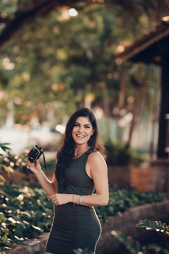 Photo of Smiling Woman in Dress Holding Black Camera