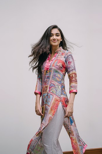 Photo of Smiling Woman in Floral Salwar Kameez Posing In Front of Gray Background