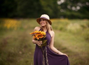 Photo of Smiling Woman in Purple Dress Holding Sunflower Bouquet
