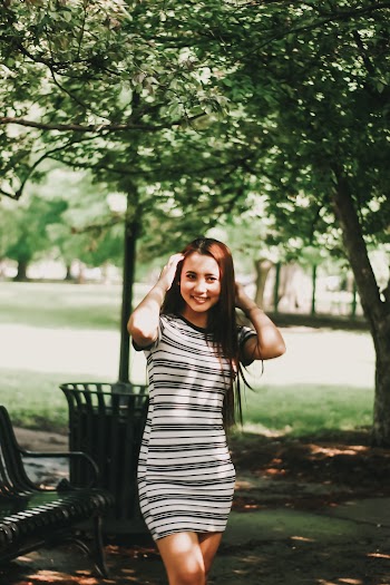 Photo of Smiling Woman in White and Black Striped Mini Dress Posing
