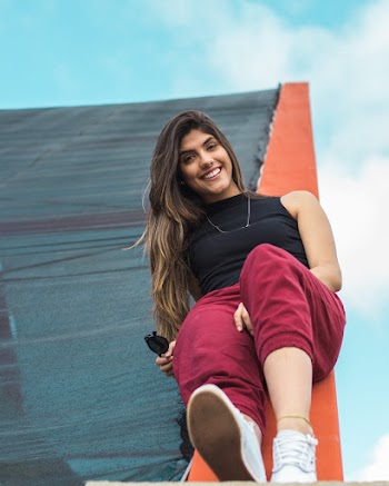 Photo of Smiling Woman Lying Down on Stone Railing Posing