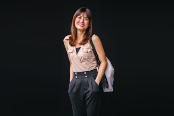 Photo of Smiling Woman Pocketing While Carrying a Bag