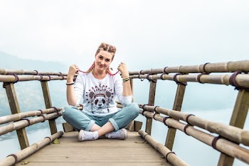 Photo of Smiling Woman Sitting on Bamboo Structure