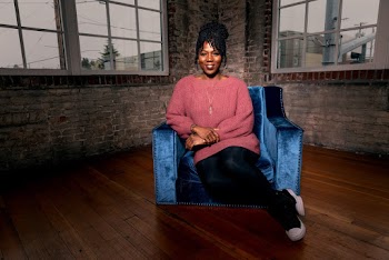 Photo of Smiling Woman Sitting on Blue Suede Sofa Armchair
