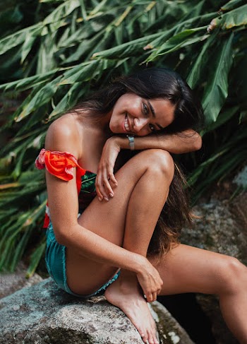 Photo of Smiling Woman Sitting on Rock