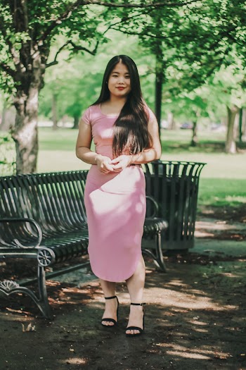 Photo of Smiling Woman Standing Beside Park Bench
