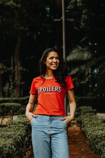 Photo of Smiling Woman Standing Between Small Bush Hedge