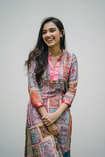 Photo of Smiling Woman Standing In Front of Gray Background