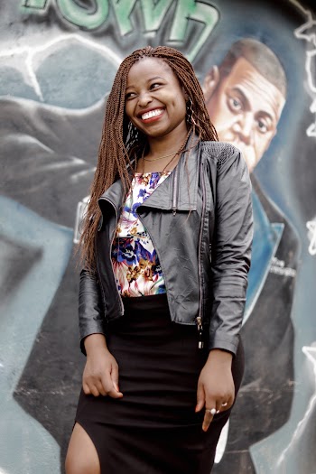 Photo of Smiling Woman Standing Near Graffiti Wall