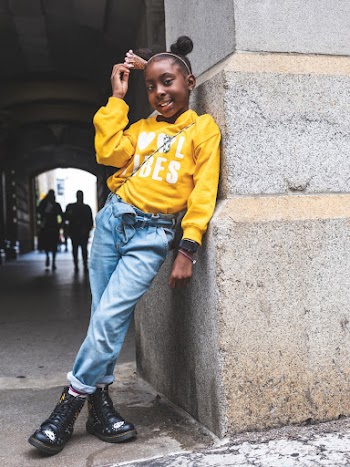 Photo of Smiling Young Girl Leaning on Wall Posing