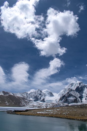 Photo of Snow Capped Mountains Under Cloudy Sky