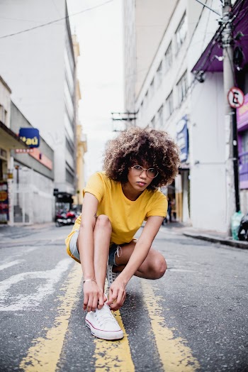 Photo of Squatting in the Middle of a Road Tying Her Shoe
