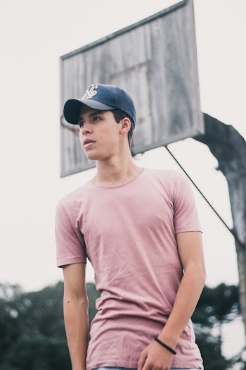 Photo of Standing Man Posing With Basketball Hoop in the Background