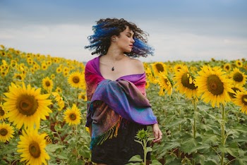 Photo of Standing Woman Flipping Her Hair in the Middle of Sunflower Field