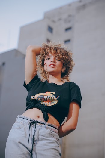 Photo of Standing Woman Holding Her Right Arm Up