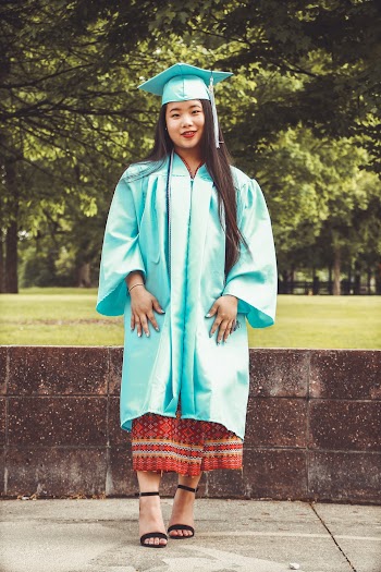 Photo of Standing Woman in Blue Academic Regalia Smiling